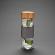 Doppelwandige Glasflasche mit Bambusdeckel und grauem Sleeve kalte Getränke