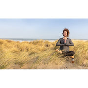 Frau am Strand mit doppelwandiger Glasflasche mit Bambusdeckel