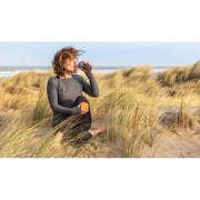 Frau am Strand mit doppelwandiger Glasflasche mit Bambusdeckel